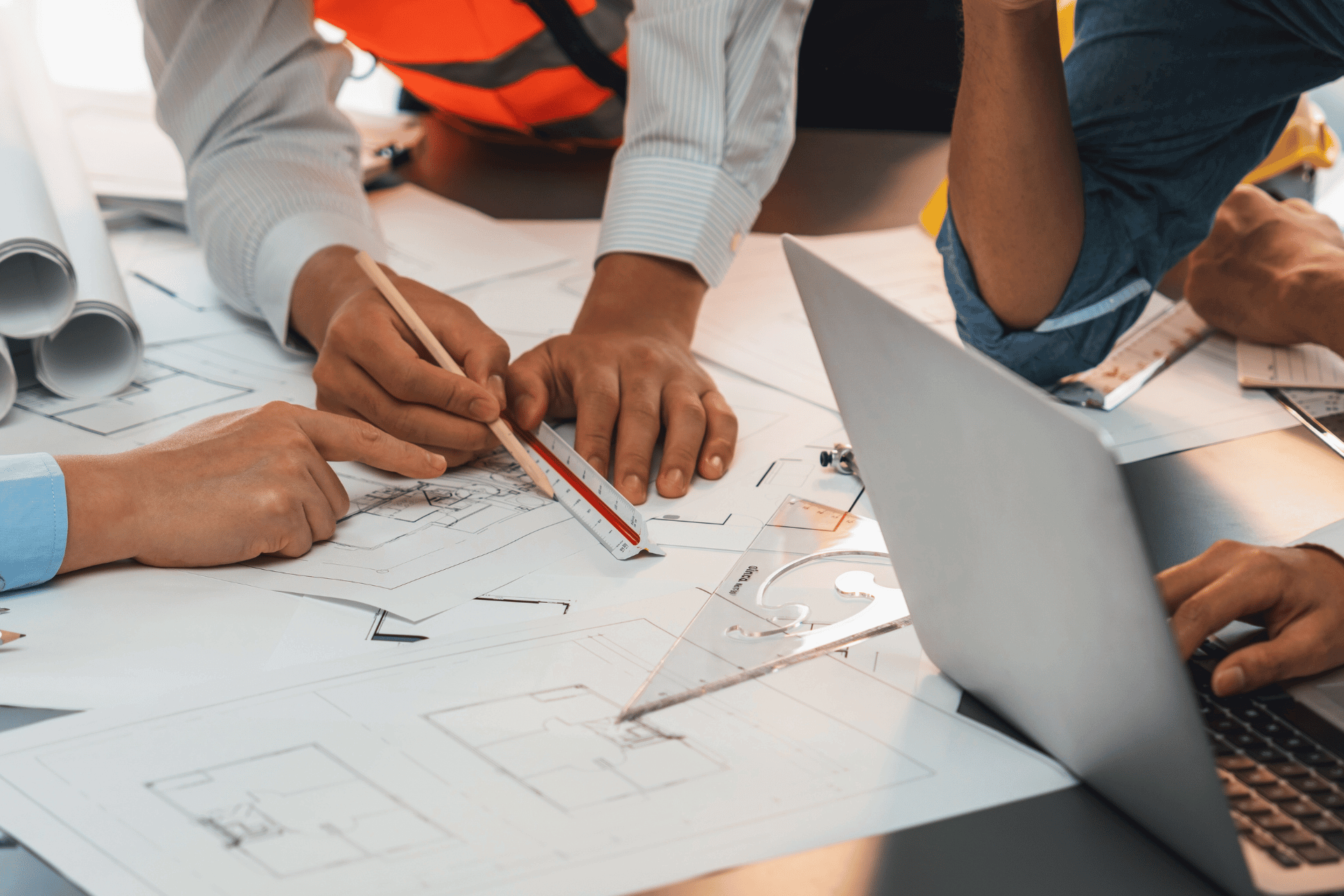 Menschen mit Bauplänen am Tisch